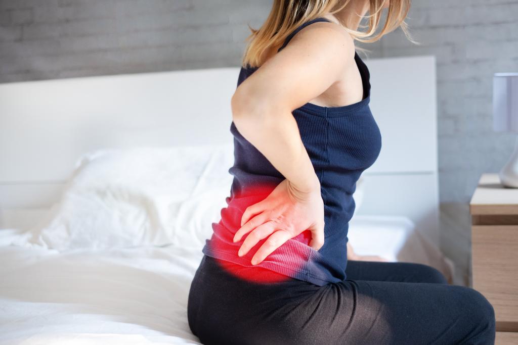 woman with hip pain on mattress